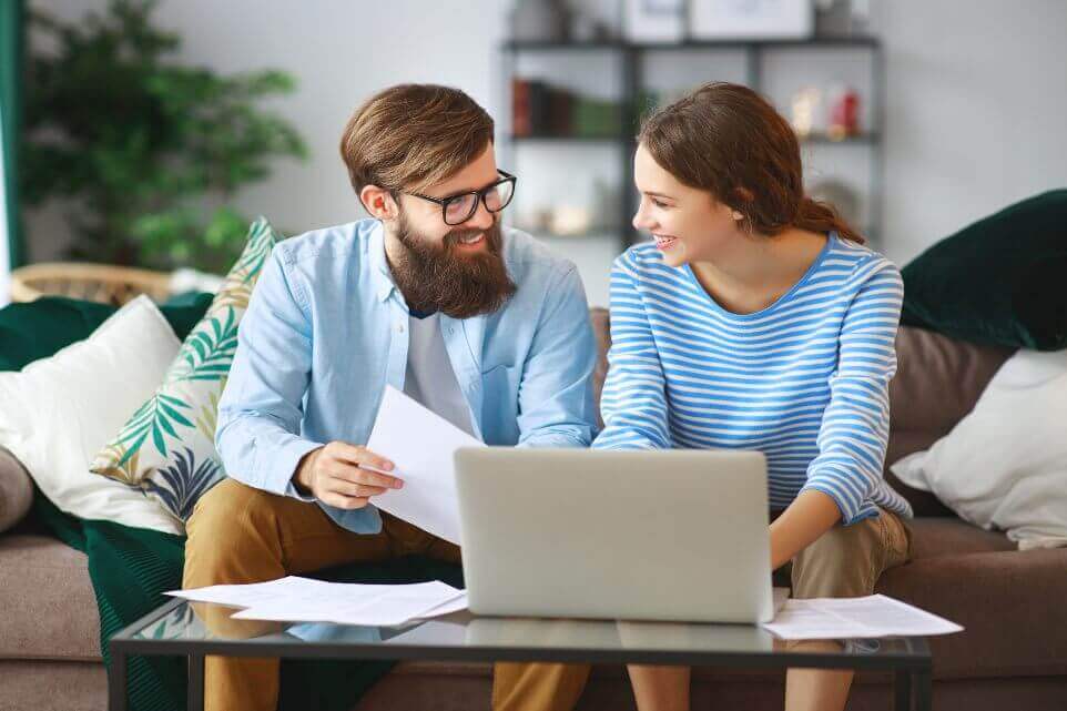 couple with bills receipts documents and laptop at home